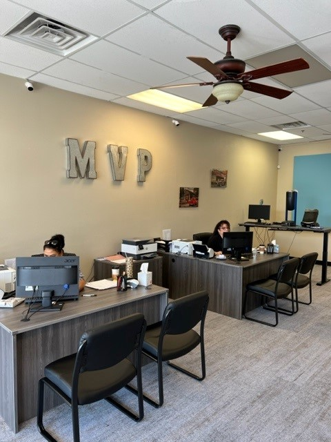 Inside an MVP office: teal accent wall, galvanized MVP letters, staff at their desks
